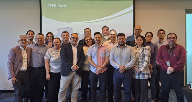 Group of 19 people participating in the workshop poses in front of PEEB Cool slides 